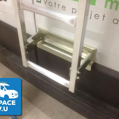 Fixation renforcée pour l'échelle en aluminium sur la porte arrière du véhicule utilitaire.